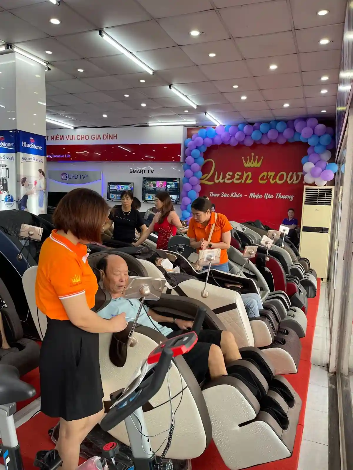 nhân viên hướng dẫn khách hàng trải nghiệm ghế massage tại cao lãnh